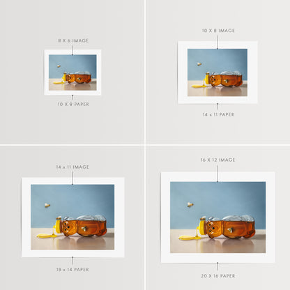 Spilled Honey & Bees Fine Art Print by Lauren Pretorius: a tipped over honey bear surrounded by a trio of honey bees.