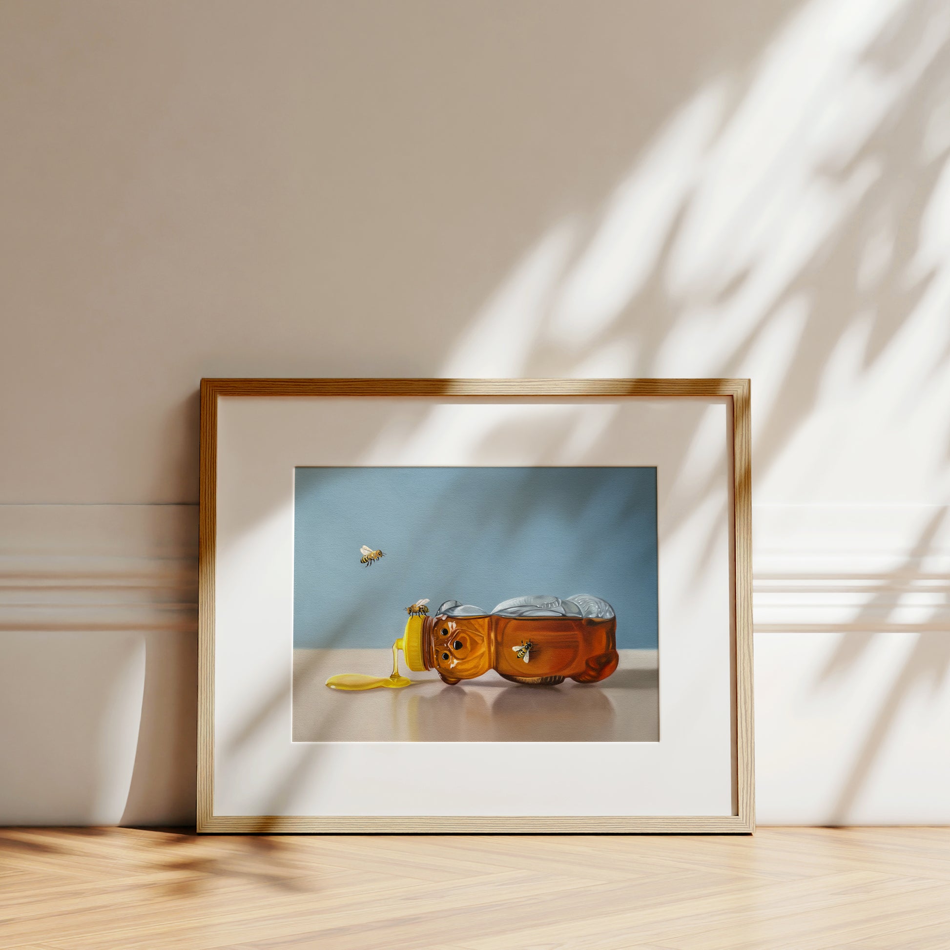 Spilled Honey & Bees Fine Art Print by Lauren Pretorius: a tipped over honey bear surrounded by a trio of honey bees.