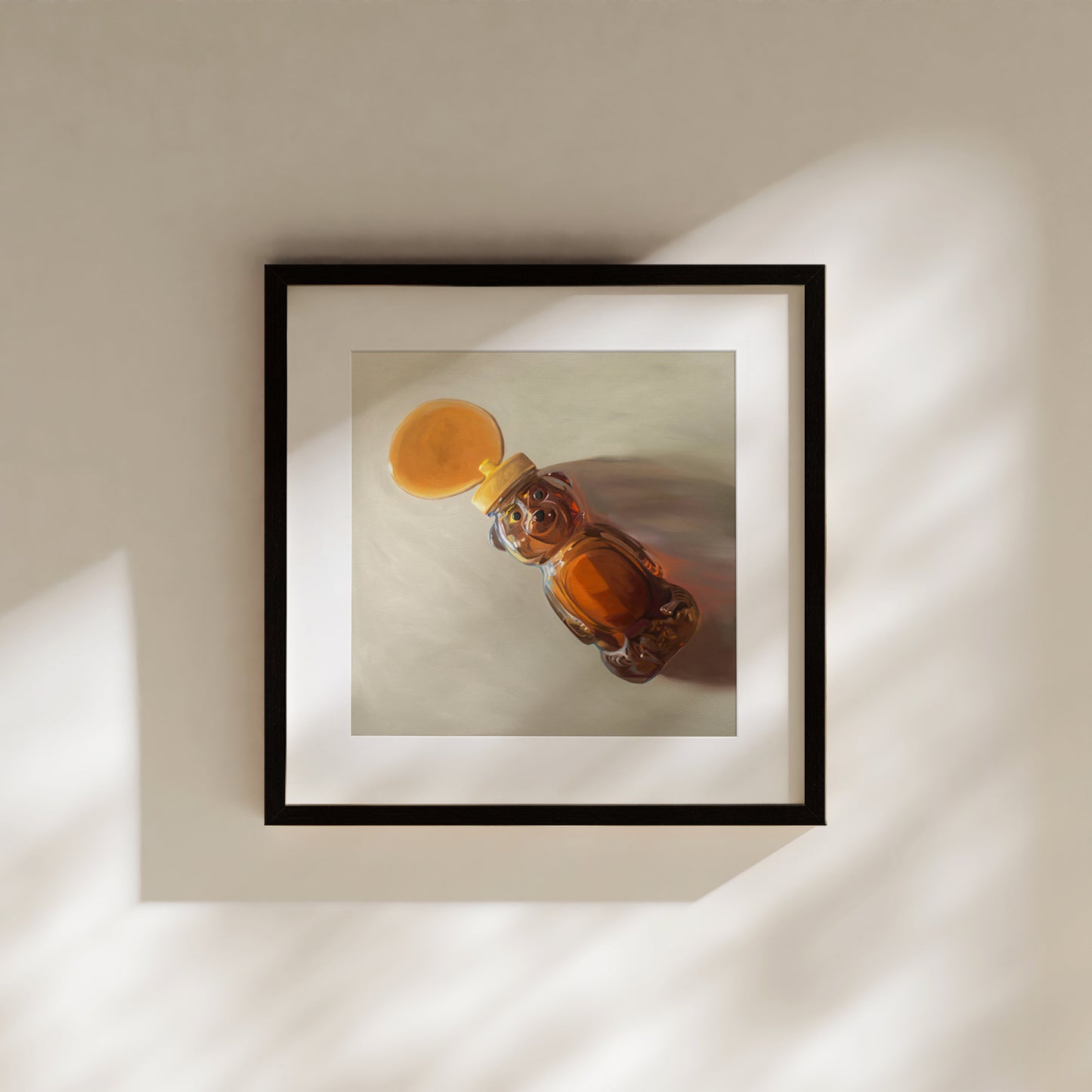 Framed fine art print of a honey bear bottle spilling golden honey, with warm light and shadows.