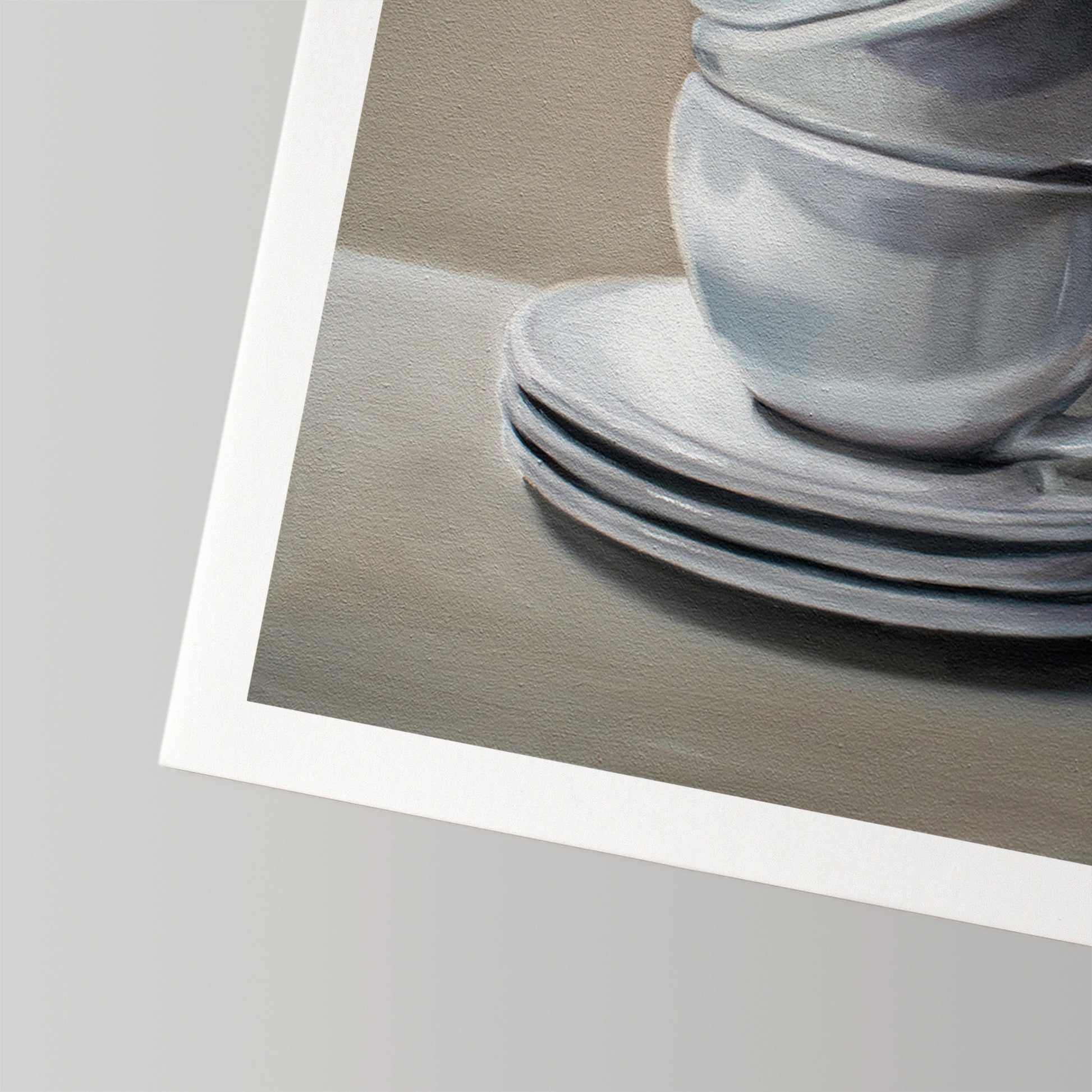 Fine art print of stacked white ceramic cups and saucers on a neutral background, with a white border.