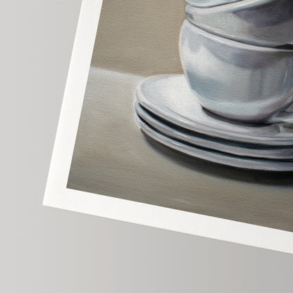 Fine art print of stacked white ceramic cups and saucers on a neutral background, with a white border.
