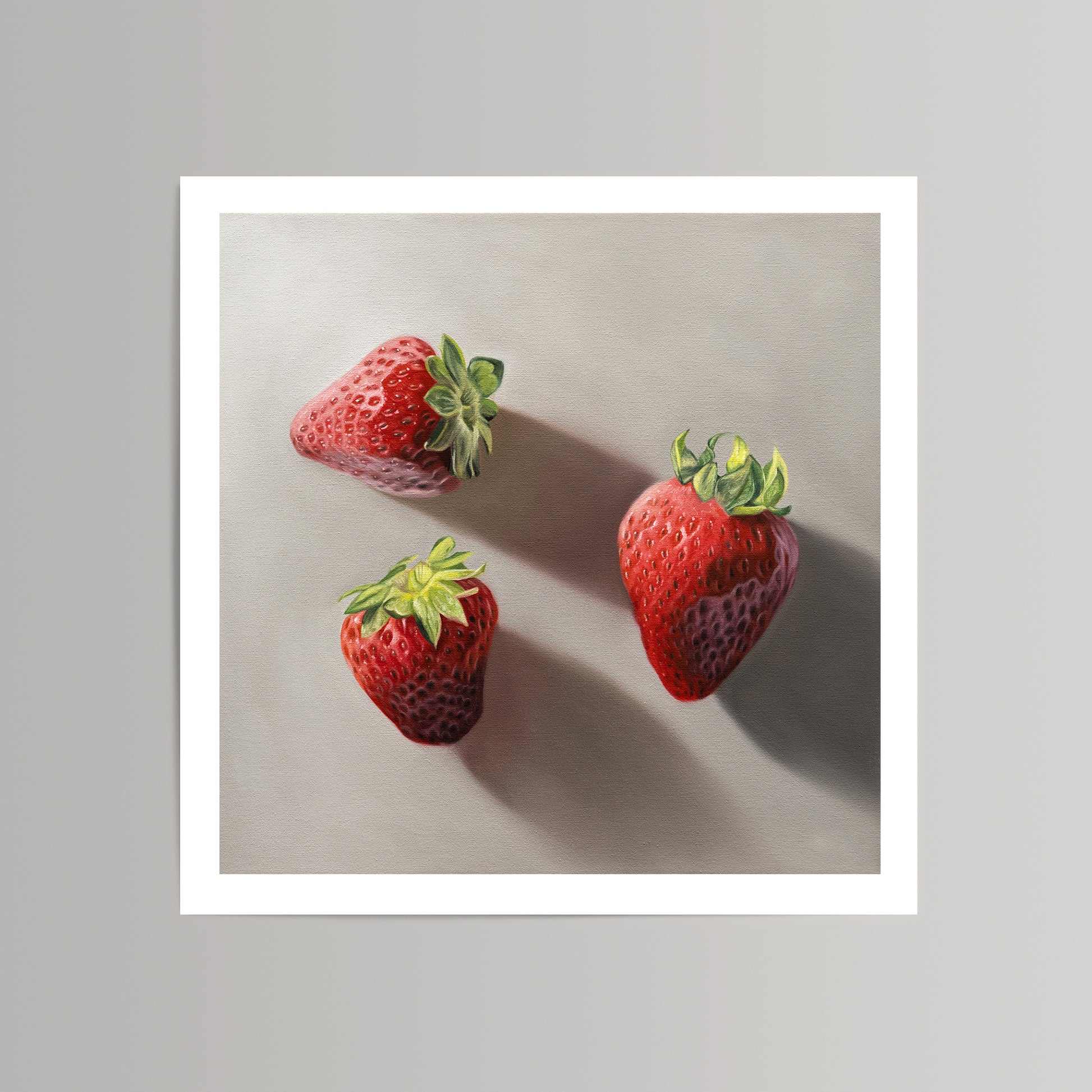 Realistic fine art print of three vibrant red strawberries with green caps on a light gray background.