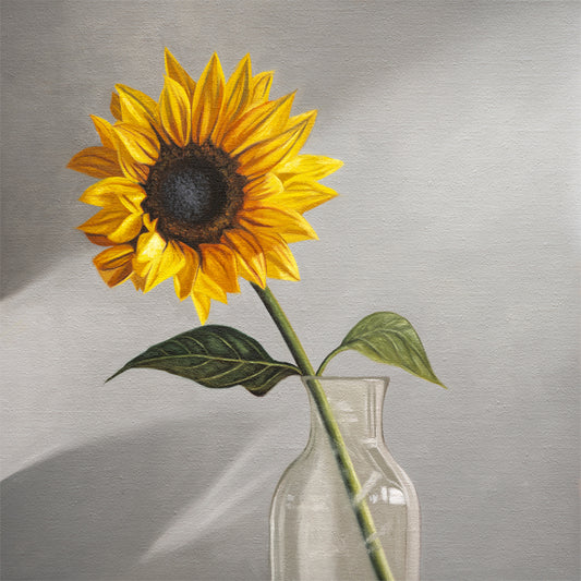 Sunflower Fine Art Print by Lauren Pretorius: a sunflower in a clear glass vase with a neutral grey backdrop.