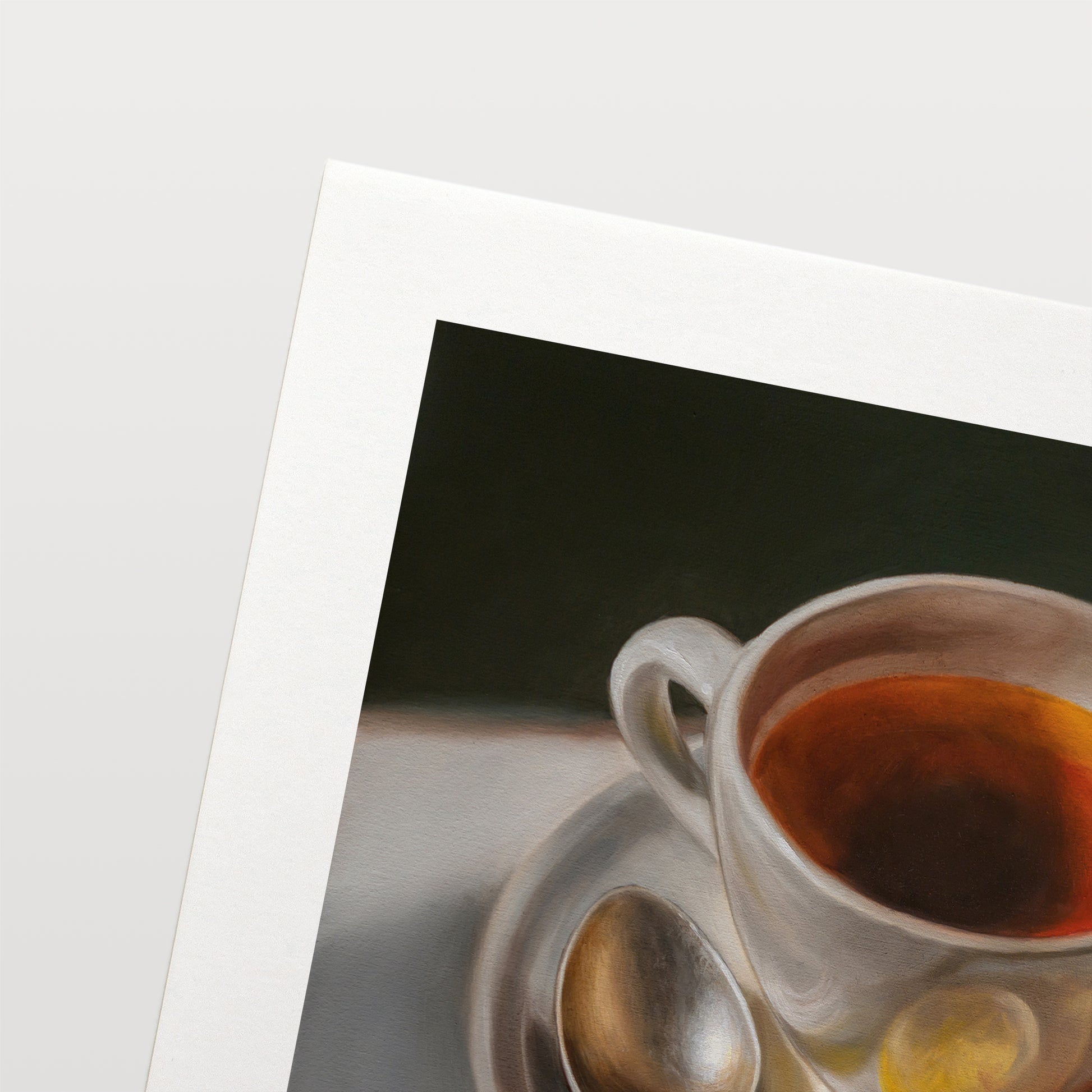 Tea with Lemons Fine Art Print by Lauren Pretorius: a cup of tea with lemon slices on a plate, accompanied by a spoon, against a light background.