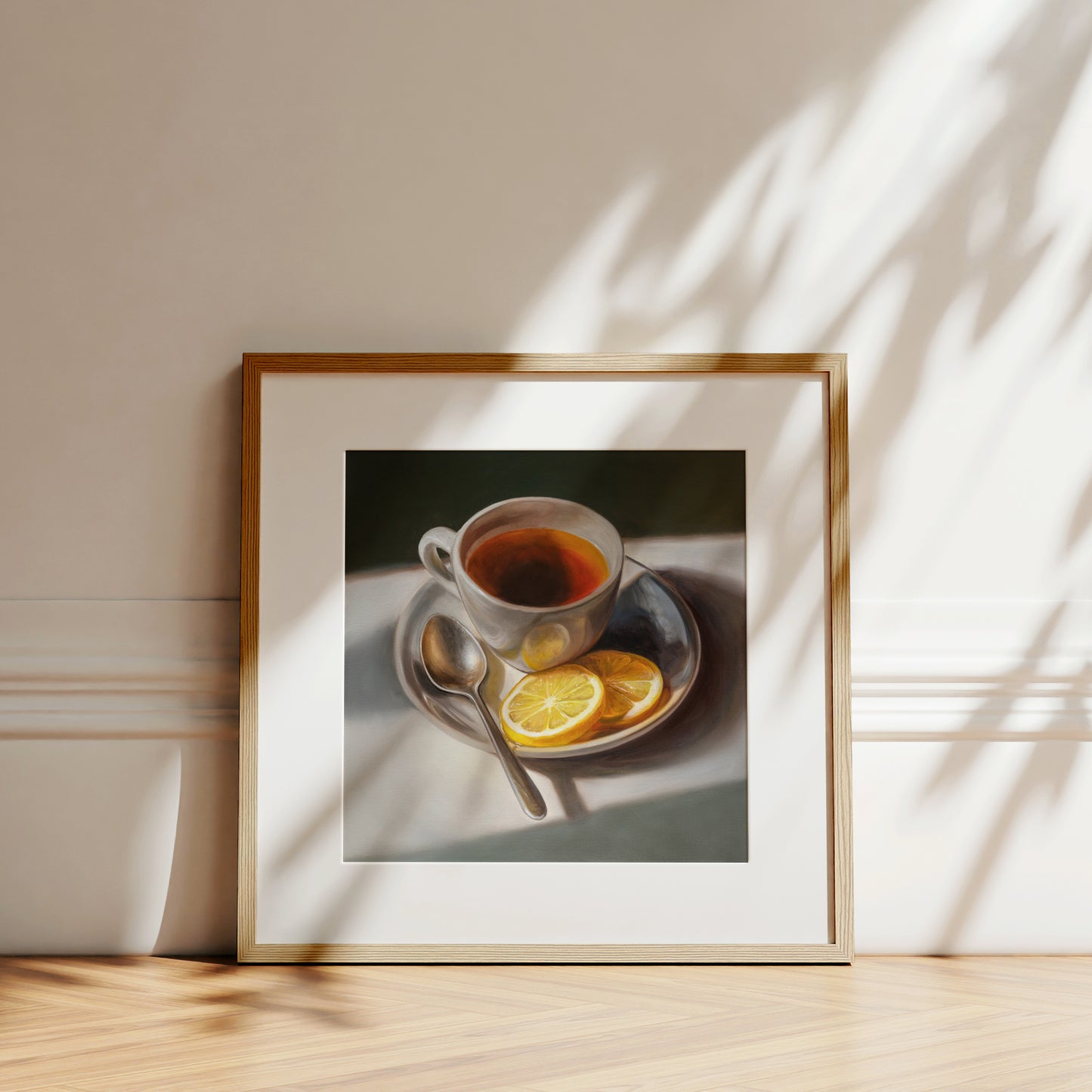 Tea with Lemons Fine Art Print by Lauren Pretorius: a cup of tea with lemon slices on a plate, accompanied by a spoon, against a light background.
