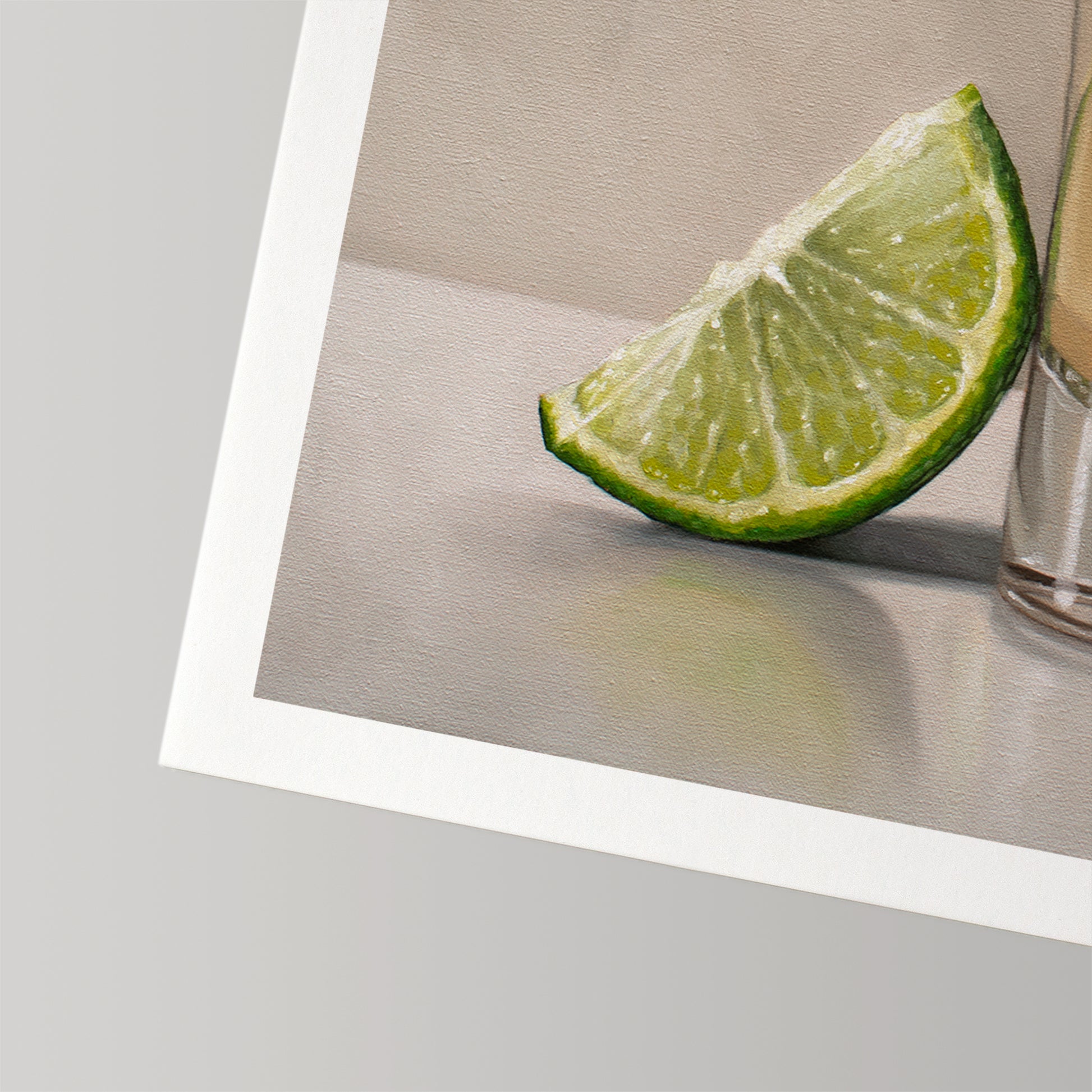 Fine art print of a vibrant green lime wedge next to a tequila glass, on museum-grade cotton rag paper.