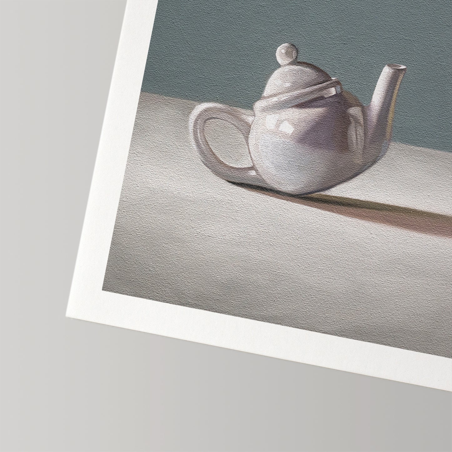 Fine art print of a white ceramic teapot with lid, casting a shadow on a light surface against a gray background.