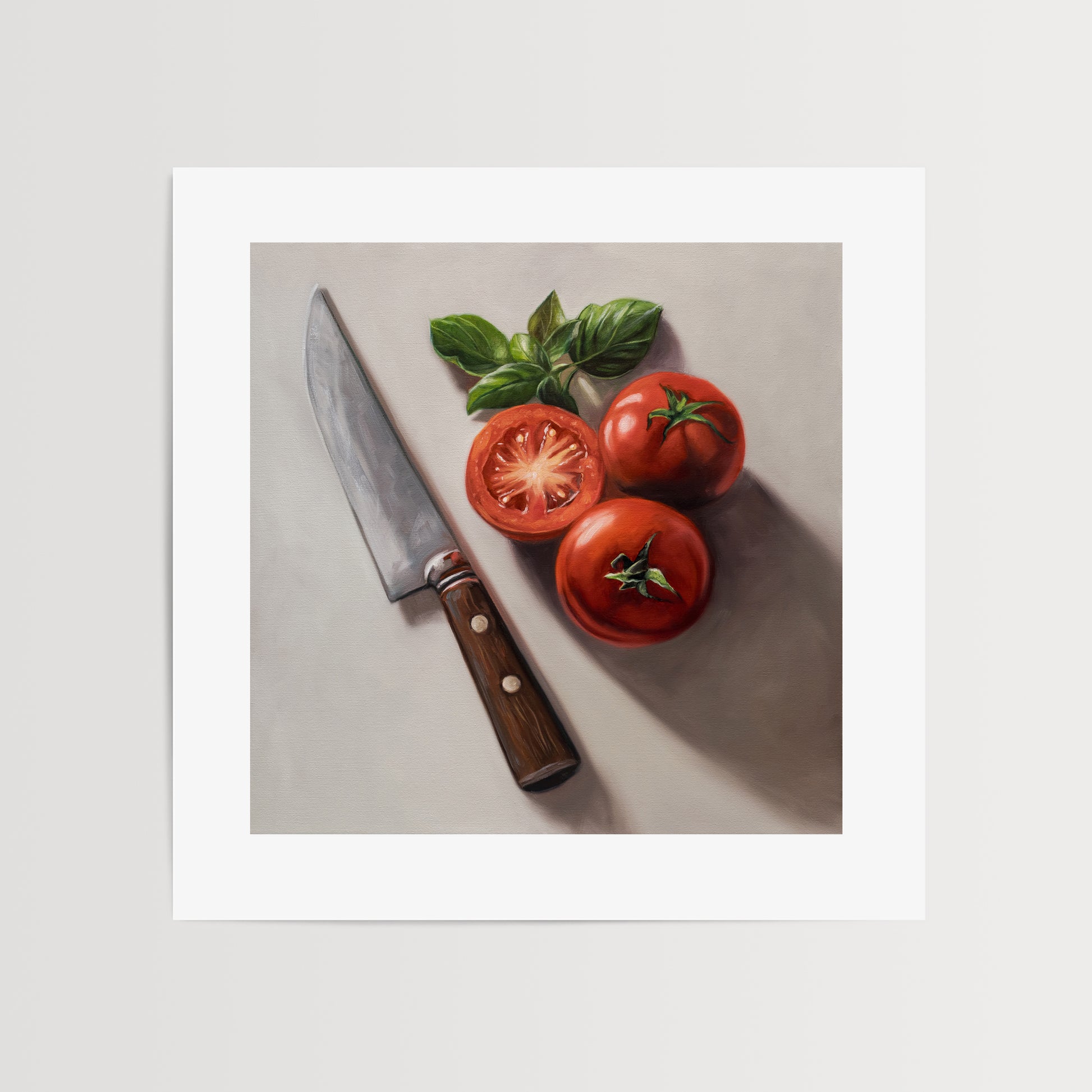 Tomato & Basil Fine Art Print by Lauren Pretorius: a knife next to three tomatoes and basil leaves on a light surface