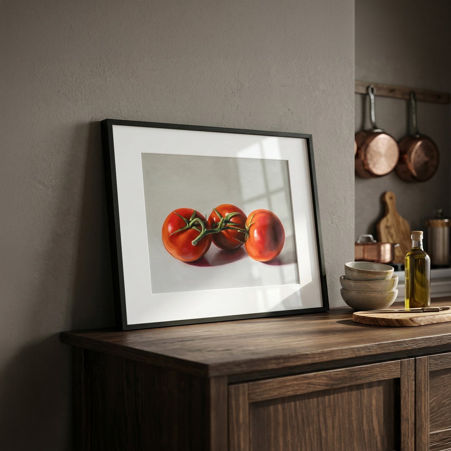 Framed fine art print of three vibrant red tomatoes, displayed on a dark wood kitchen counter.