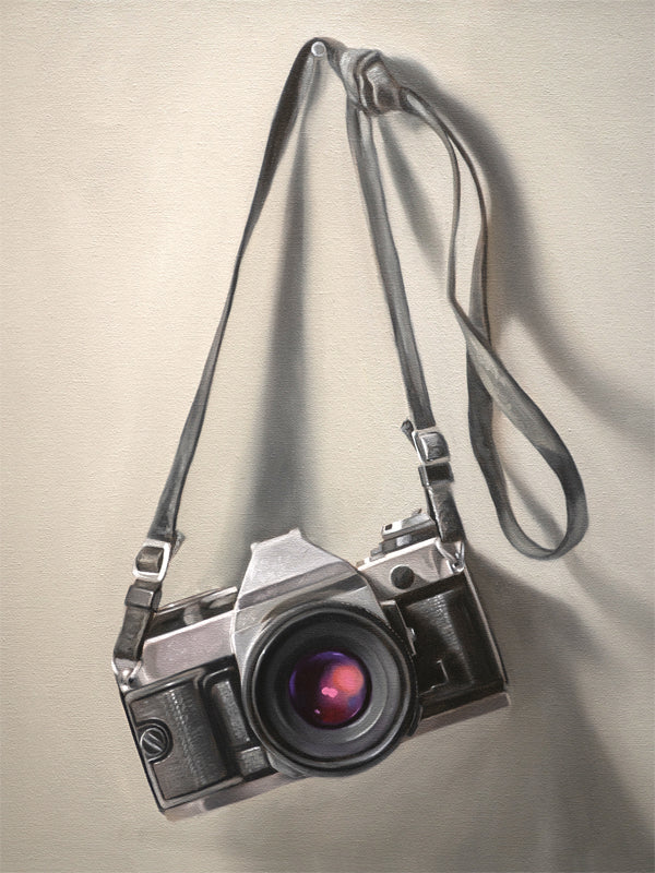 Vintage Film Camera Fine Art Print by Lauren Pretorius: a vintage 35mm camera hanging from its strap with some nice dramatic lighting.