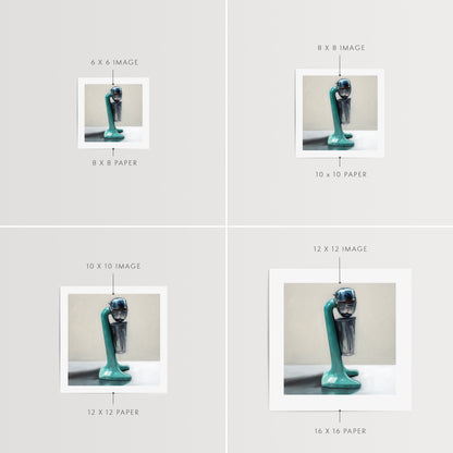 Vintage Milkshake Mixer Fine Art Print by Lauren Pretorius: a vintage turquoise milkshake mixer resting on a light reflective surface and grey background.