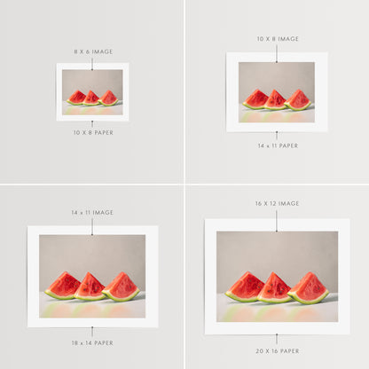 Watermelon Slice Trio Fine Art Print by Lauren Pretorius: a freshly sliced trio of watermelon wedges lined up on a reflective surface with some nice dramatic lighting.