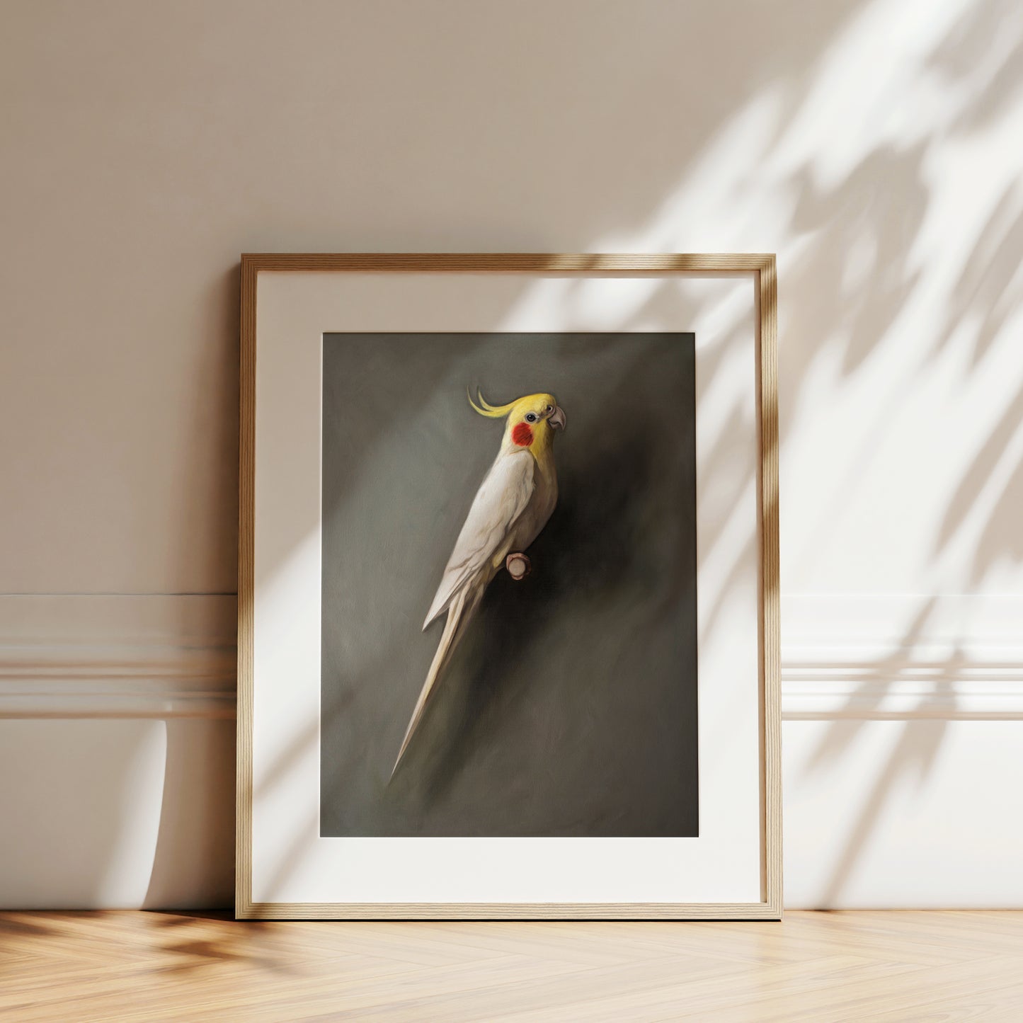 Framed fine art print of a white cockatiel with a yellow crest and red cheek patch, on a dark background.