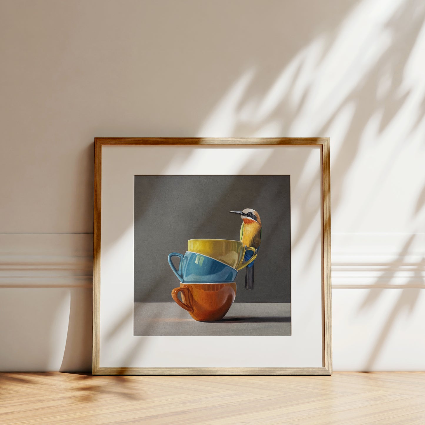 Framed fine art print of a colorful bee-eater bird perched on a stack of yellow, blue, and orange cups.