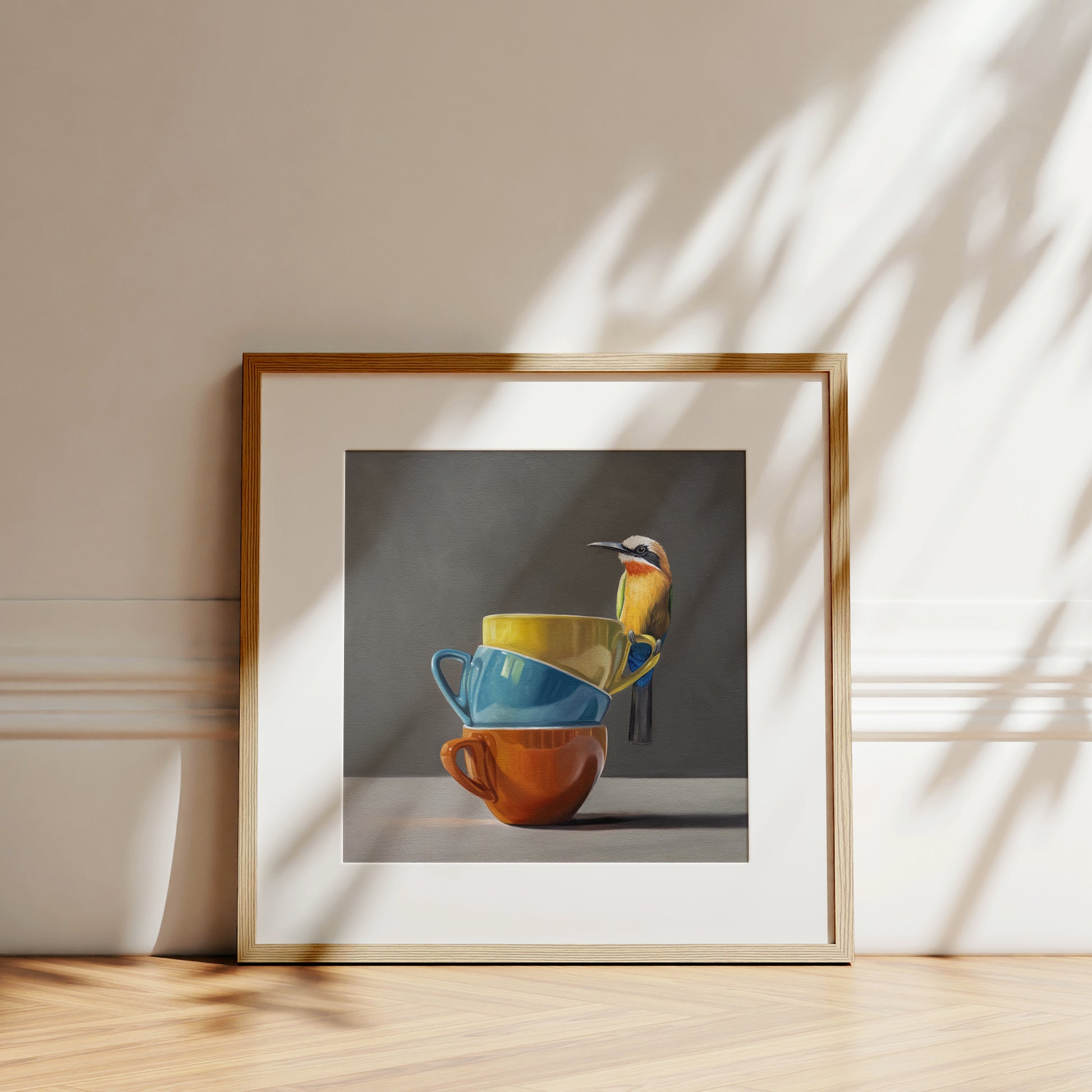 Framed fine art print of a colorful bee-eater bird perched on a stack of yellow, blue, and orange cups.