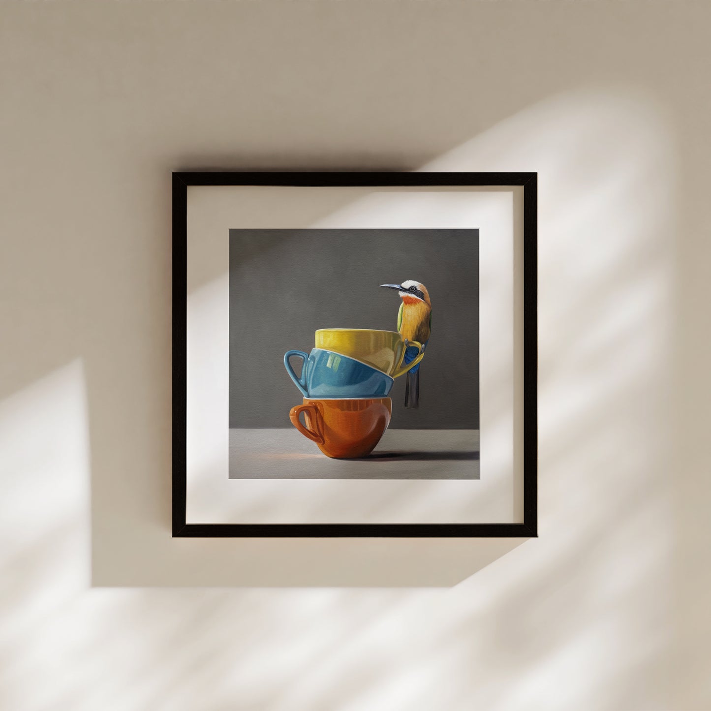 Framed fine art print of a colorful White Fronted Bee Eater perched on stacked yellow, blue, and orange cups.