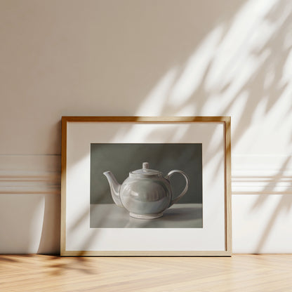 Fine art print of a white teapot with subtle reflections, framed in light wood.